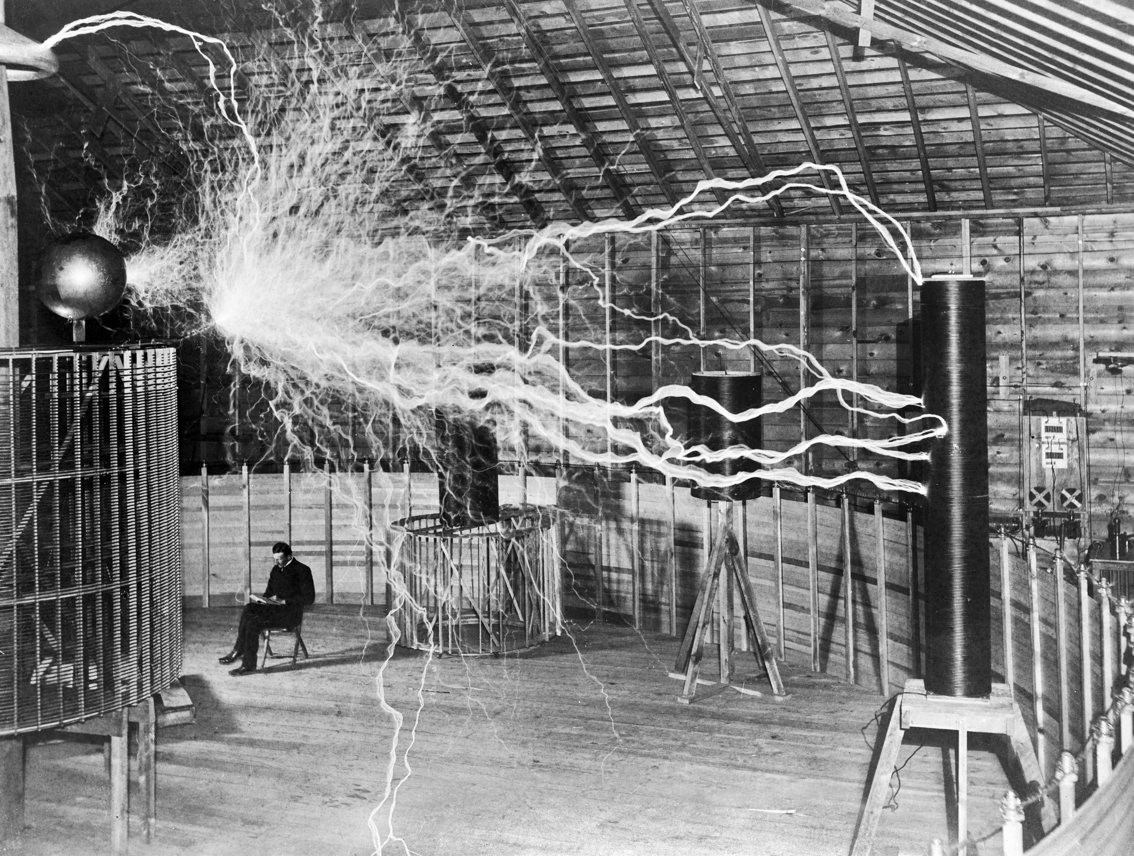 Nikola Tesla in the lab with the Tesla Coil producing flashes